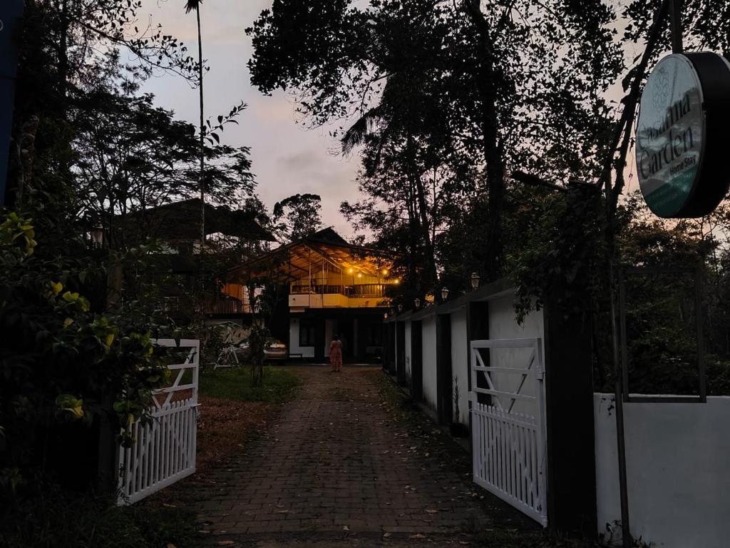 a brick road with a white fence and a building at Forest Soul by BOB in Batheri