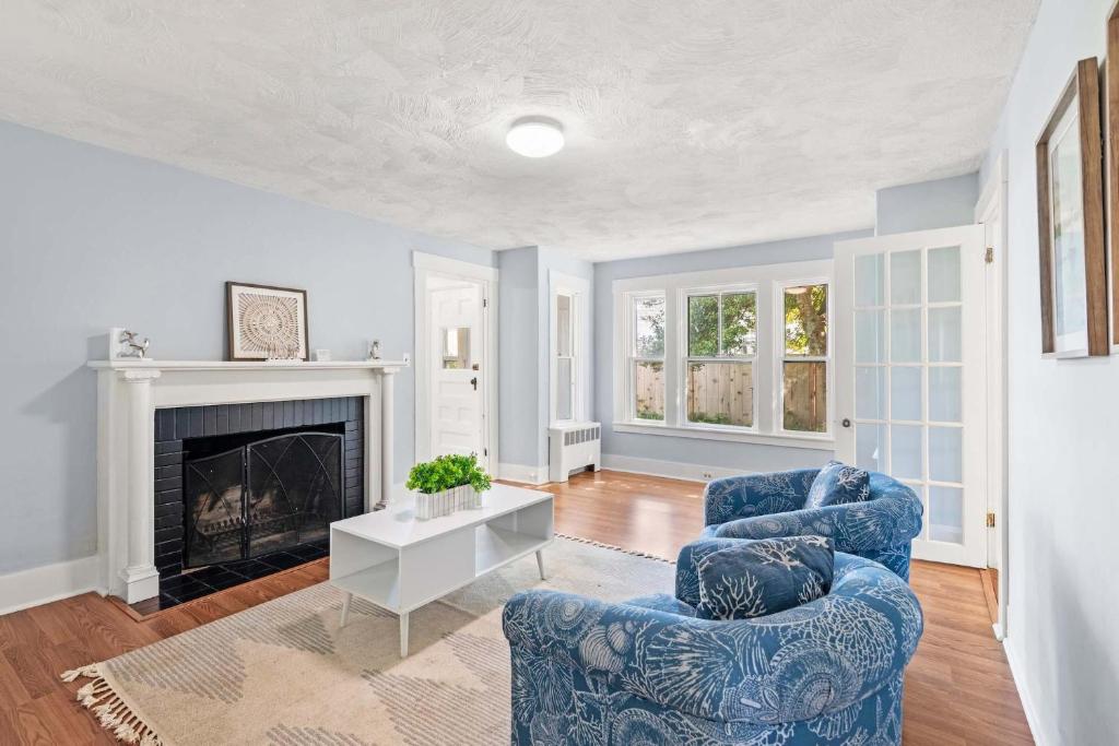 un salon avec deux chaises bleues et une cheminée dans l'établissement Renovated Classic Cape w Guest House, à Dennis
