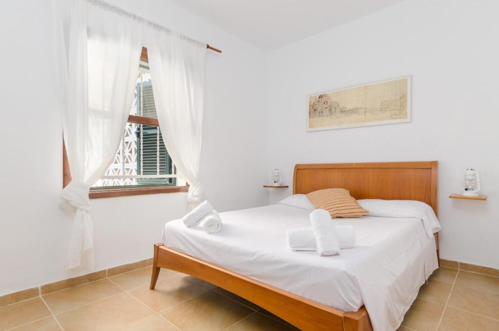 Una habitación blanca con una cama y una ventana en YourHouse Ca Na Salera, en Palma de Mallorca