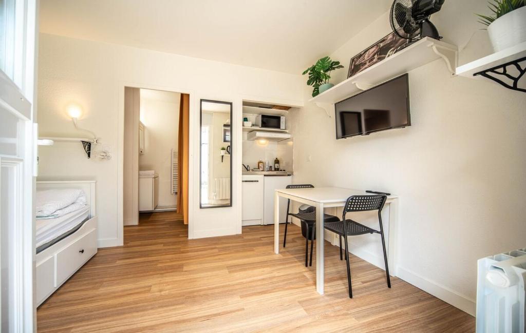 a small room with a table and a kitchen at Boucicaut Yellow Studio in Chalon-sur-Saône