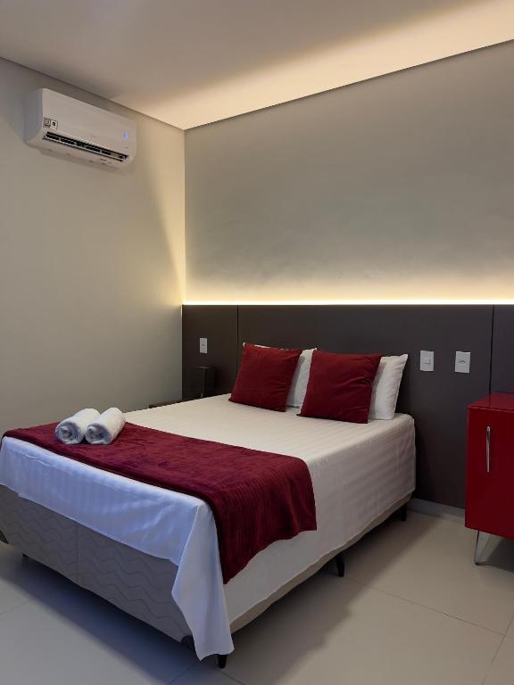 里约布兰科Cubo Hotel的卧室里有一张大床，配有红色枕头