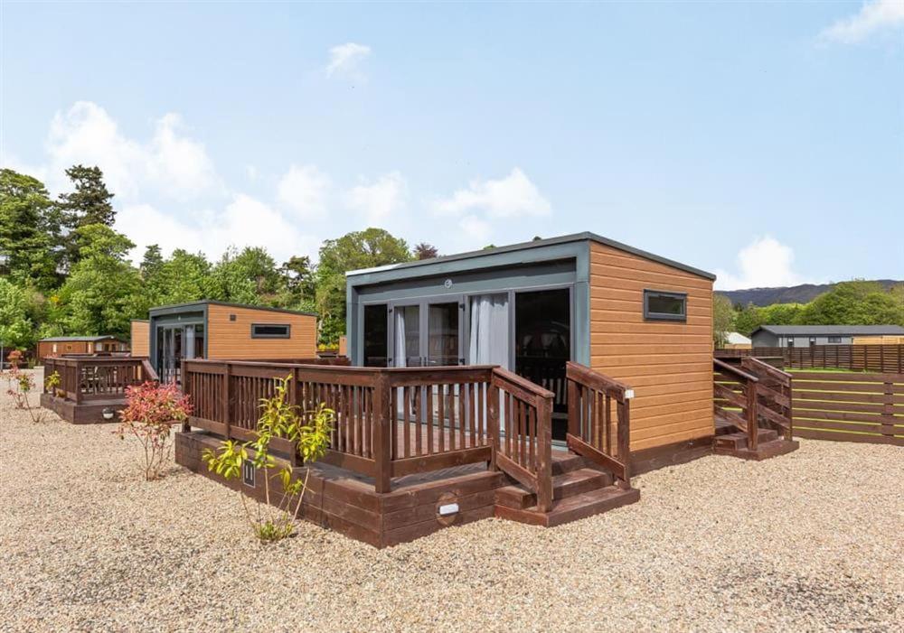 a small cabin with a porch and a deck at LOCH NESS HIGHLAND Resort in Fort Augustus