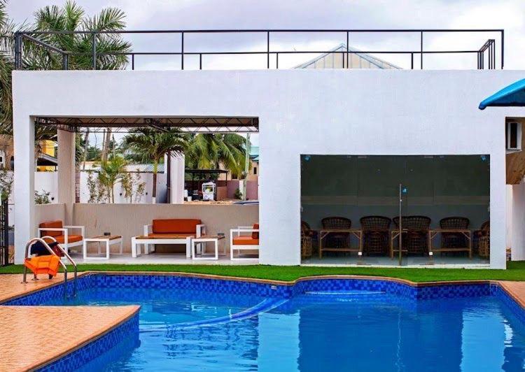 a swimming pool in front of a house at Hotel Spintex and tours in Accra