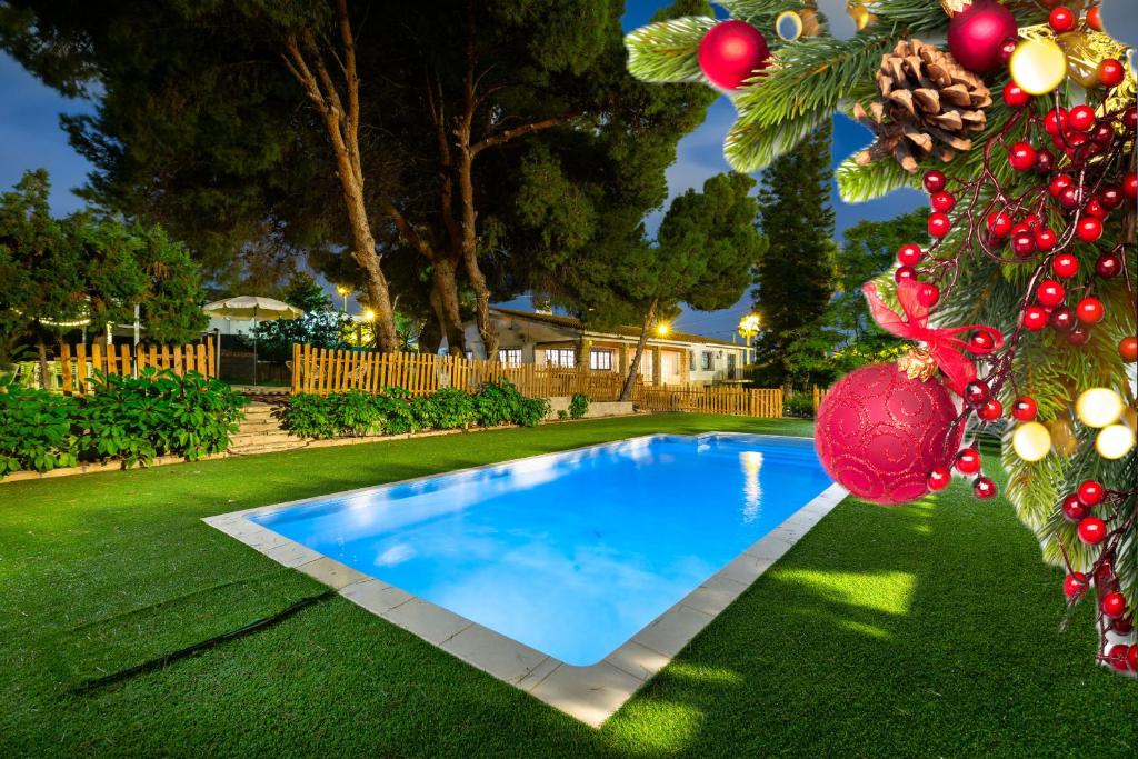 a swimming pool in a yard with a christmas tree at The Urban Mansion by Fidalsa in Alicante