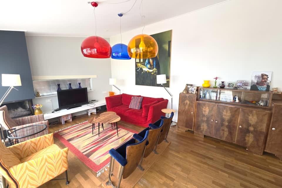 a living room with a red couch and a table at Hello Zeeland - Margrietenlaan 5 in Oostkapelle