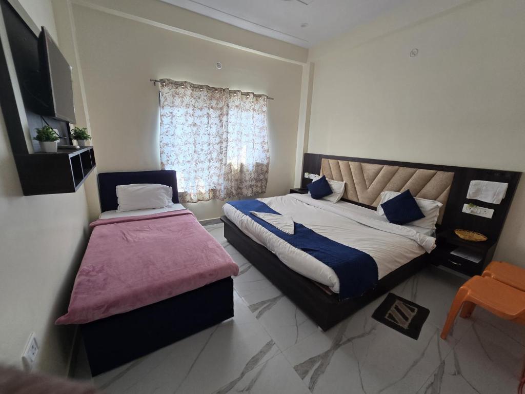 a bedroom with two beds and a window at Abhi palace Ayodhya in Ayodhya