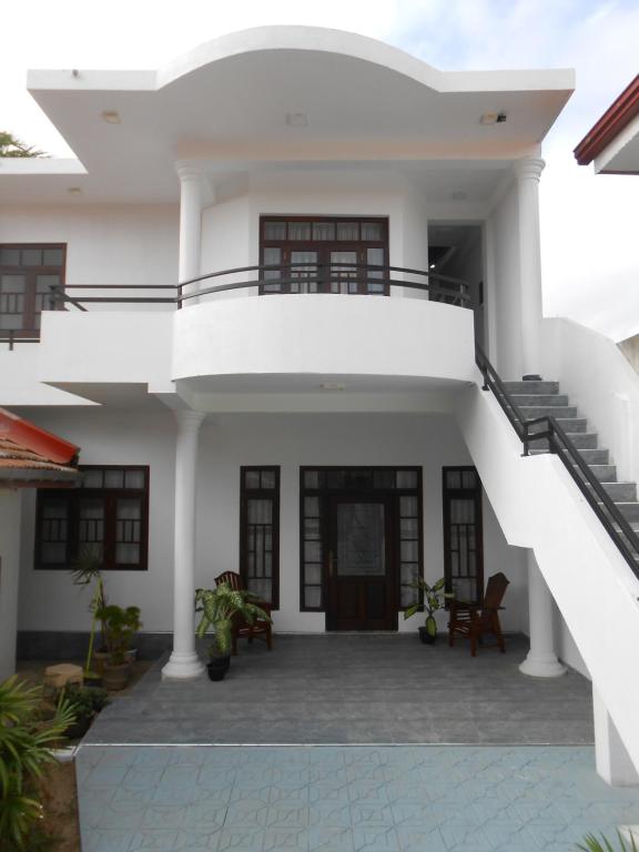 une maison blanche avec un escalier en face de celle-ci dans l'établissement Villa Rodrigo, à Negombo