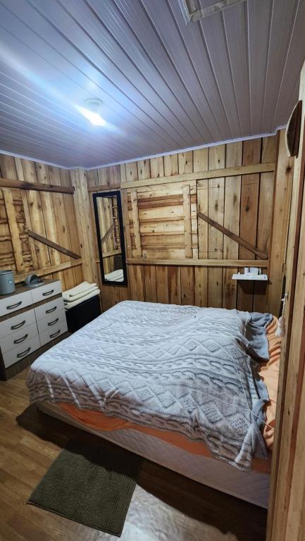 una camera da letto con un letto e una parete di legno di Rancho do Brow a Camboriú