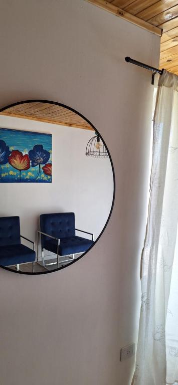 two blue chairs in a room with a mirror at La casita in Zapala