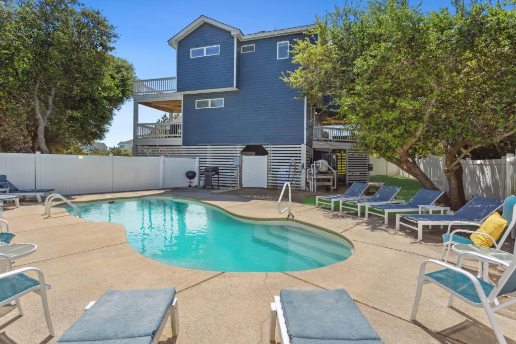 ein Swimmingpool mit Stühlen und ein Haus in der Unterkunft 1009 - Land's End in Corolla