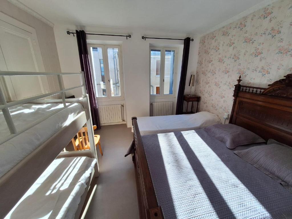 1 Schlafzimmer mit 2 Etagenbetten und 2 Fenstern in der Unterkunft La Saint-Mametoise in Saint-Mamet