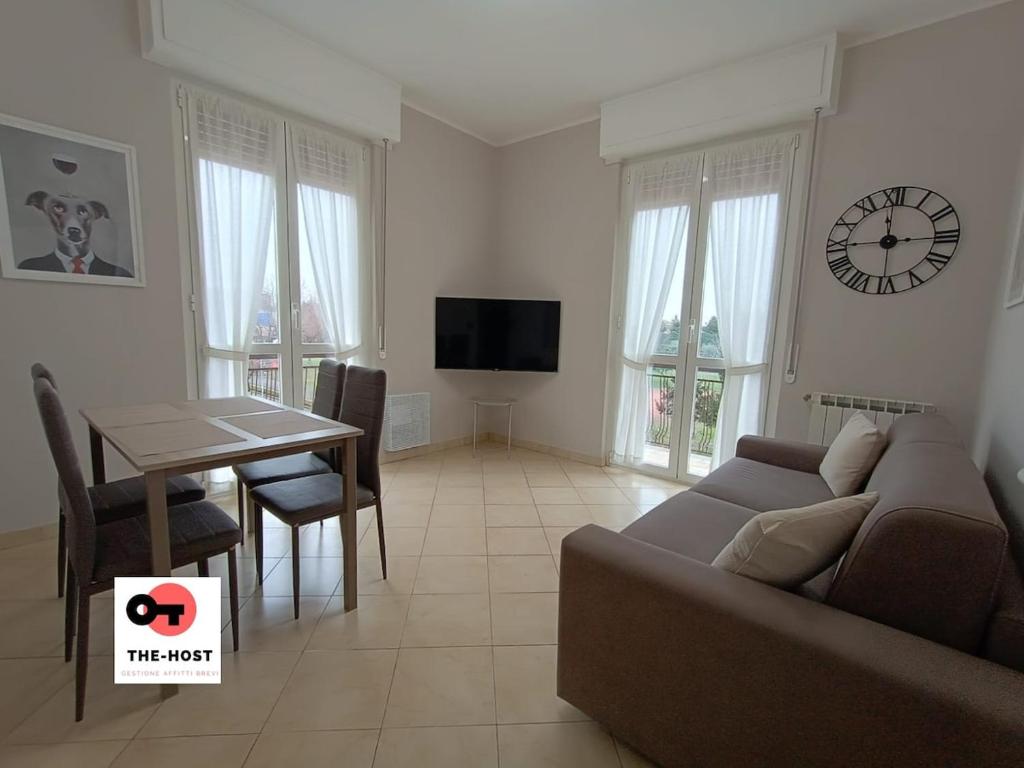 a living room with a couch and a table and a clock at Vimodrone, modern accommodation near San Raffaele in Vimodrone