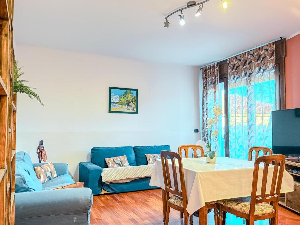 Una sala de estar con un sofá azul y una mesa. en MYHOUSE INN RACCONIGI - Affitti Brevi Italia, en Turín