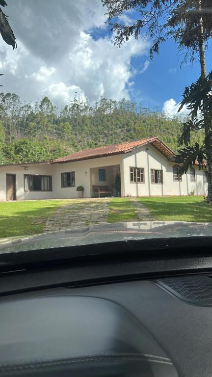 Man sieht ein Haus aus dem Inneren eines Autos. in der Unterkunft Casa em Pedra Azul in Pedra Azul