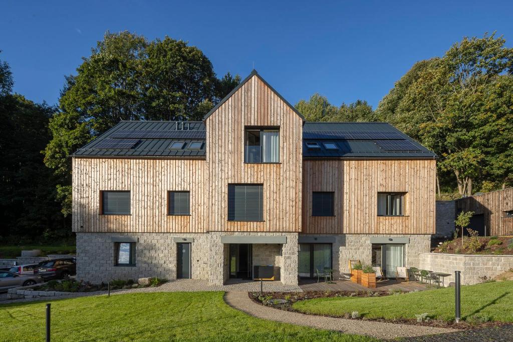 une maison avec des panneaux solaires dessus dans l'établissement Apartmány Hraničná s privátním wellness, à Bedřichov