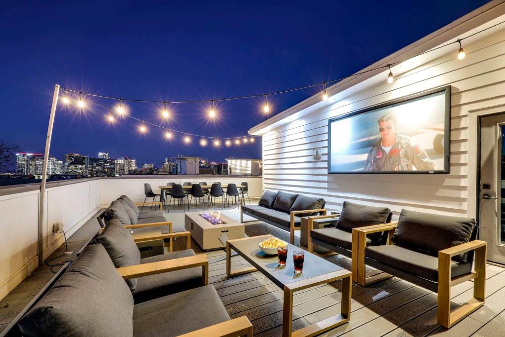 a rooftop patio with couches and a tv on the wall at Luxury Condo - The Gulch - Private Rooftop in Nashville