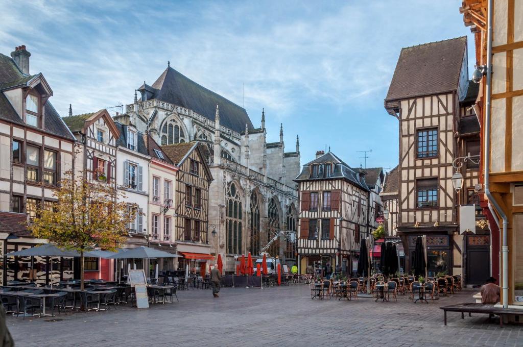 a city street with tables and chairs and buildings at T2 Cosy avec jardin et parking gratuit à Troyes in Troyes