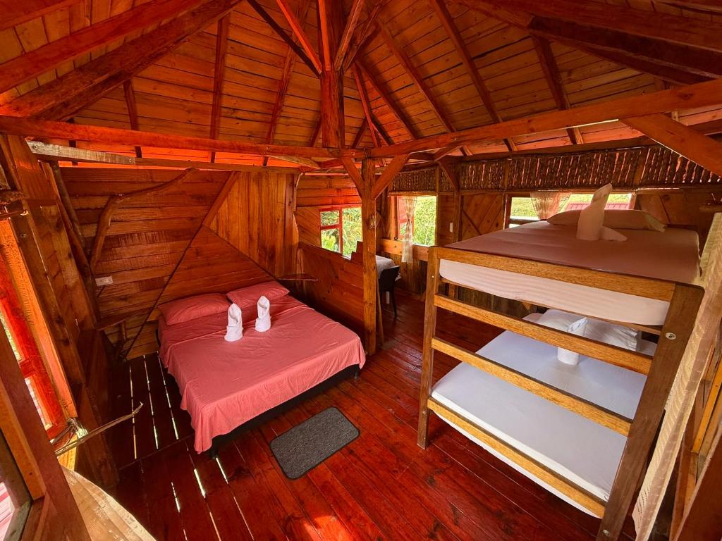ein Zimmer mit zwei Betten in einer Holzhütte in der Unterkunft Wila House Rural in Gigante
