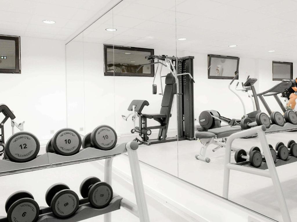 une salle de fitness avec un miroir et des poids dans l'établissement IBIS Port de plaisance, à Caen