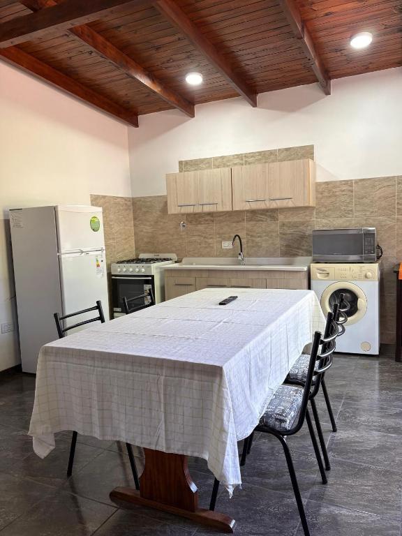a kitchen with a table with two chairs and a refrigerator at Dos Osos in Villa General Belgrano
