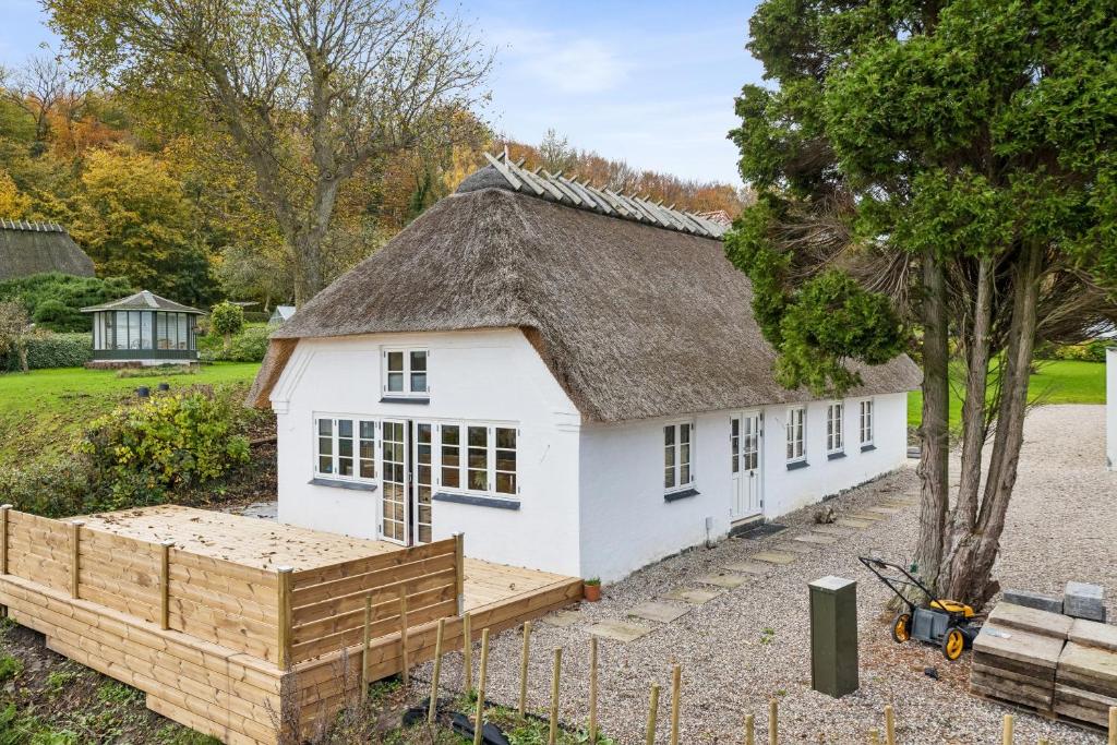 a small white building with a thatched roof at Stråtækt feriehusidyl ved vandet in Sønderborg