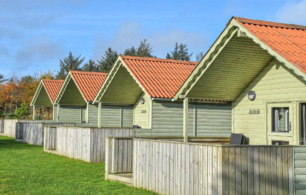 PugdalStunning Home In Hanstholm With Outdoor Swimming Pool的围栏后面一排有红色屋顶的房屋