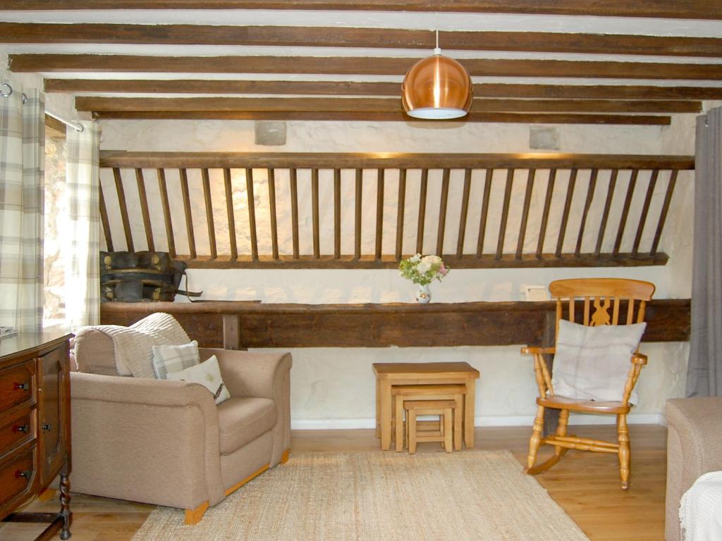 ein Wohnzimmer mit einer Couch und einem Sessel in der Unterkunft Shire Cottage in Highpeak Junction