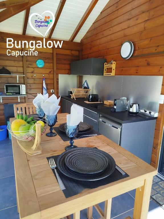 a kitchen with a table with plates on it at Bungalow Capucine in Capesterre-Belle-Eau