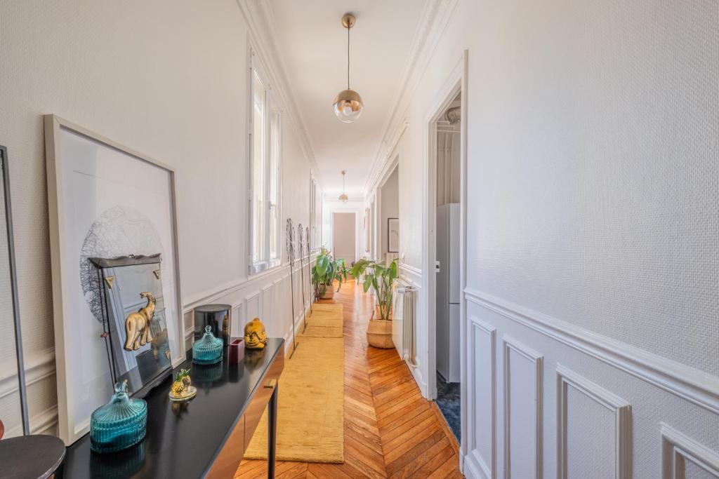 einen Flur mit weißen Wänden und einem Tisch in einem Zimmer in der Unterkunft Parisian Escape and Jacuzzi and green Vibes in Paris