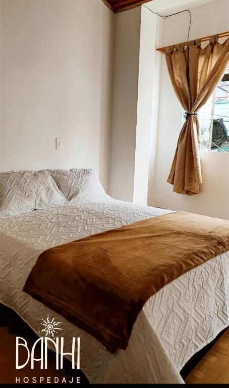 a bedroom with a bed and a window at Hospedaje Banhi in Líbano
