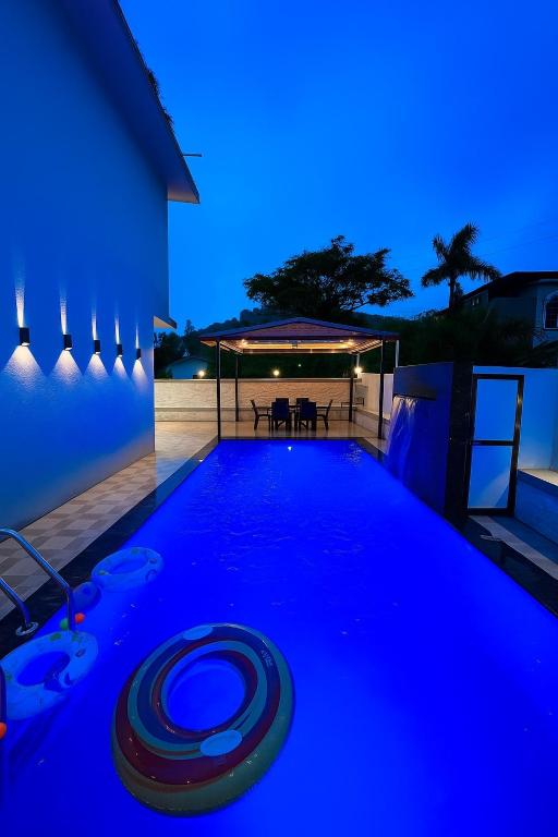 a swimming pool in the middle of a house at night at 3 BHK Mount Villa by Asmeera Stays in Lonavala