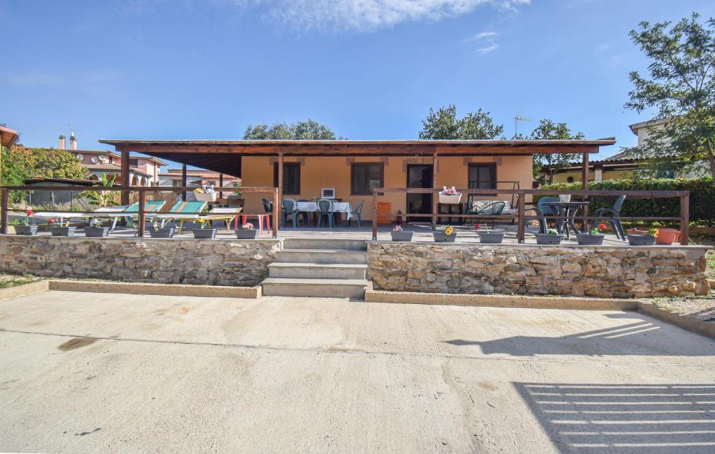 a house with a stone wall and a patio at Lovely Home In Civitavecchia in Aurelia