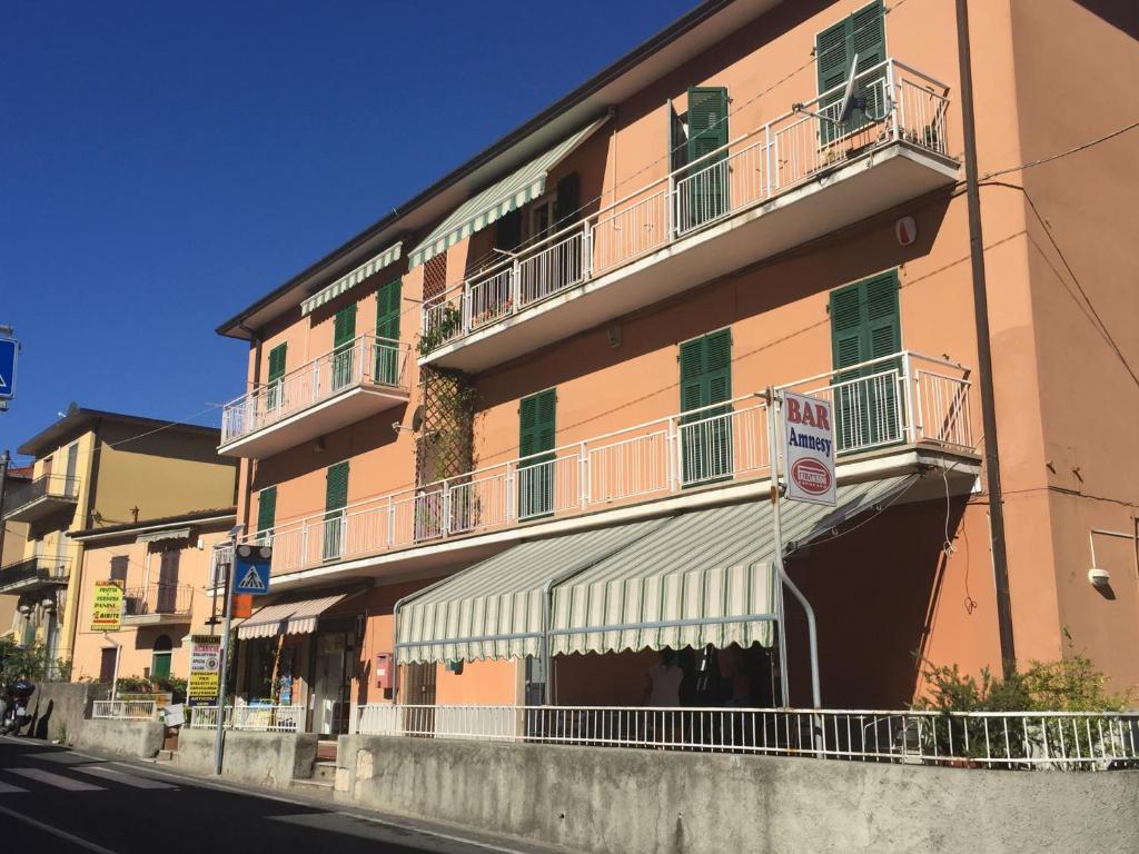 een hoog roze gebouw met balkons en geen parkeerbord bij Appartamento Un Giorno Di Sole in Lerici