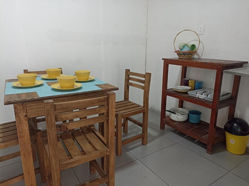 une table avec des bols jaunes dessus et une étagère dans l'établissement Cómoda habitación, à Pátzcuaro