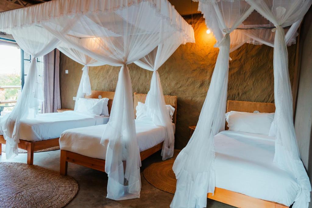 a bedroom with two beds with mosquito nets at Kutoka Lodge in Arusha