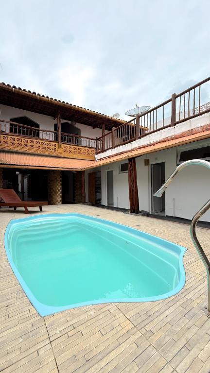 a large blue swimming pool in front of a house at Pousada Maken Hary - Centro in Arraial d'Ajuda
