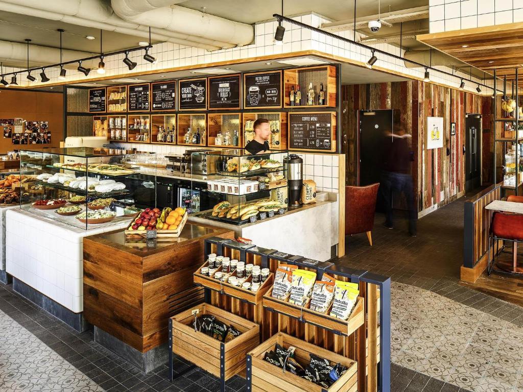 une boulangerie avec une personne debout derrière un comptoir dans l'établissement ibis Cambridge Central Station, à Cambridge