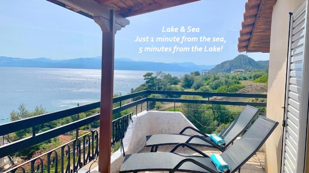 a balcony with two chairs and a view of the water at Lake and Sea in Vouliagmeni Lake