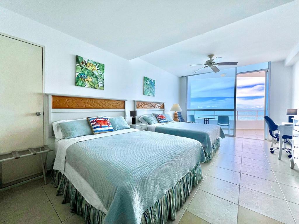 two beds in a bedroom with a view of the ocean at Encantador estudio frente al mar en Coronado Bay in Las Lajas