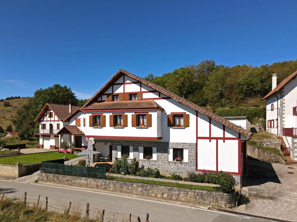 a white and red house on the side of a road at Casa Sortalde Agroturismo in Abaurrea Alta