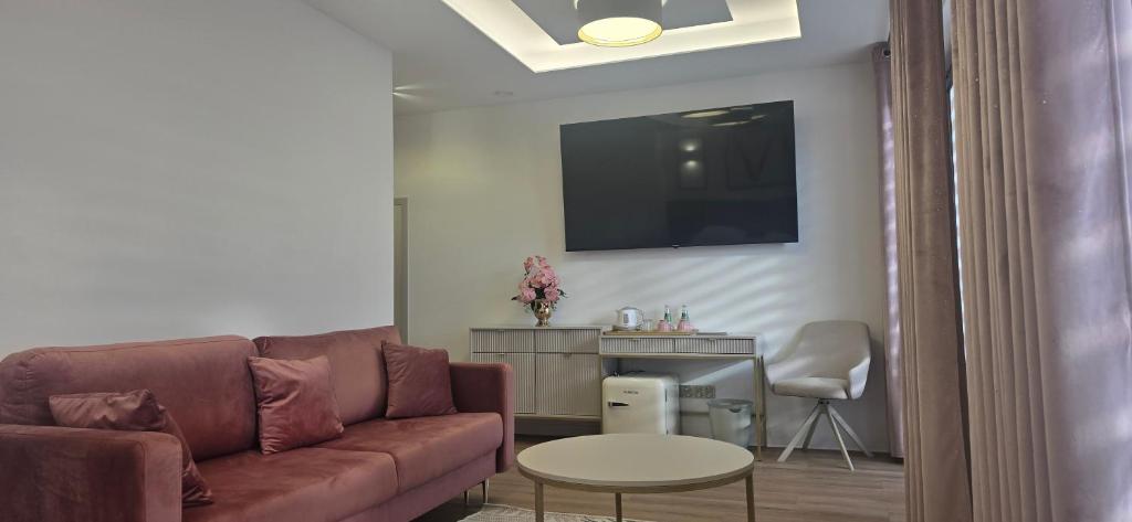 ein Wohnzimmer mit Sofa und Tisch in der Unterkunft VENETIA-Rooms in Biecz