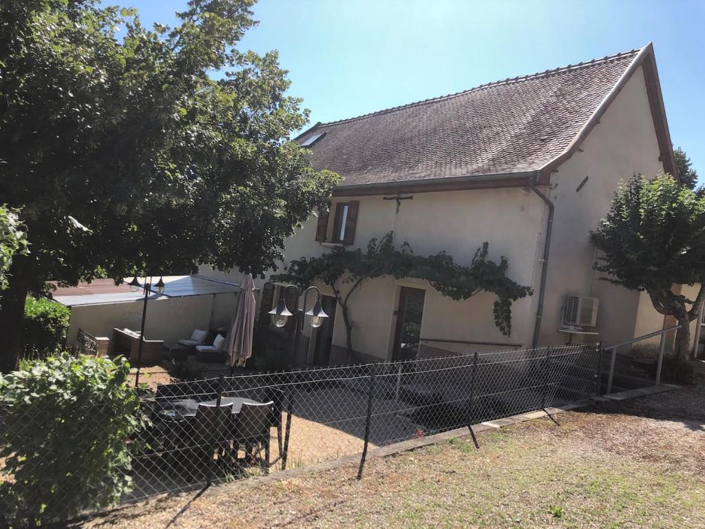 a white house with a fence in front of it at Gîte La Chaumine in Brangues