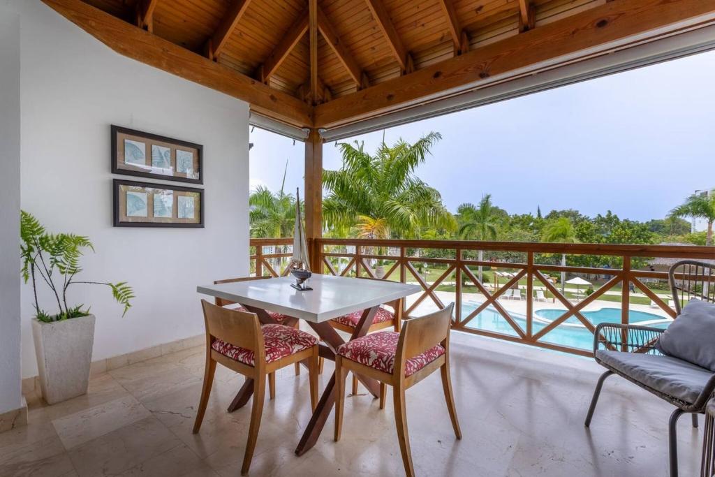 a dining room with a table and chairs on a balcony at Fortunity Club- Playa Dorada, Pto Plata in Sampiño