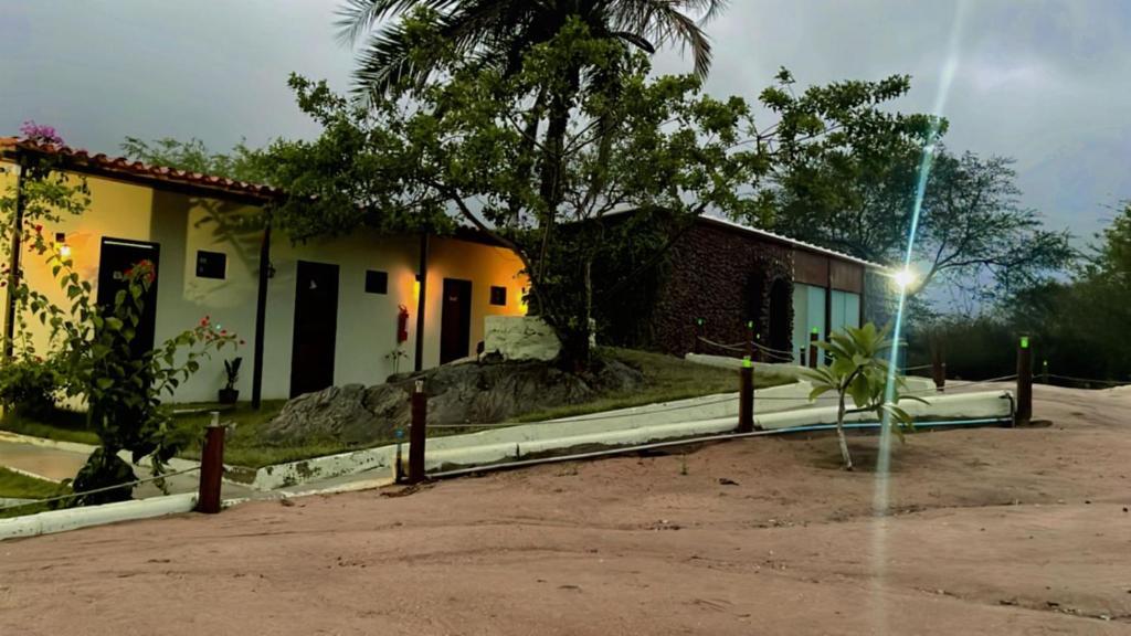 a house with a tree in front of it at Suítes Domo do Matto in Garanhuns