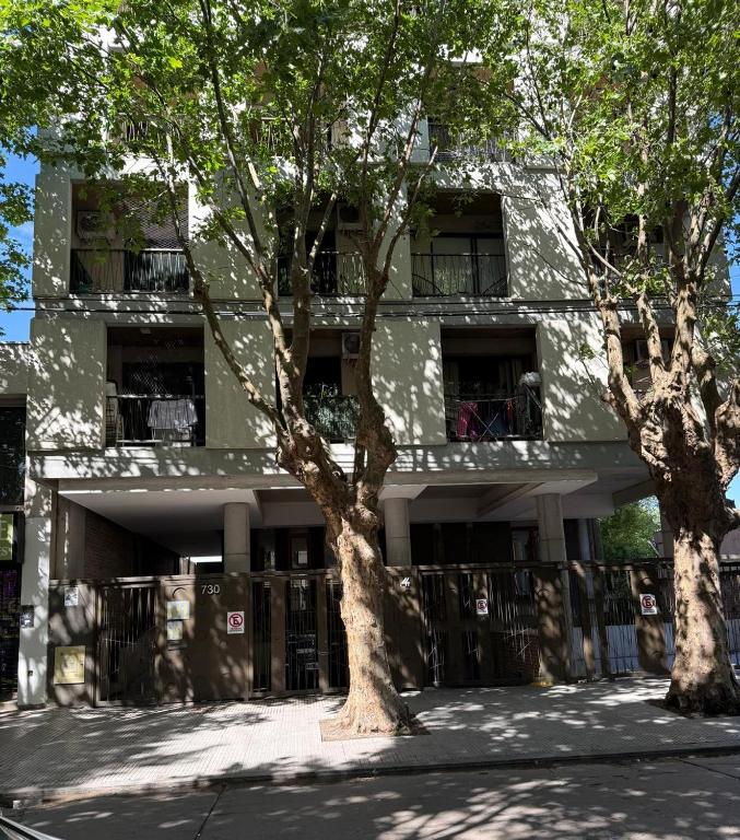 ein Gebäude mit zwei Bäumen davor in der Unterkunft Escobar Centro in Belén de Escobar