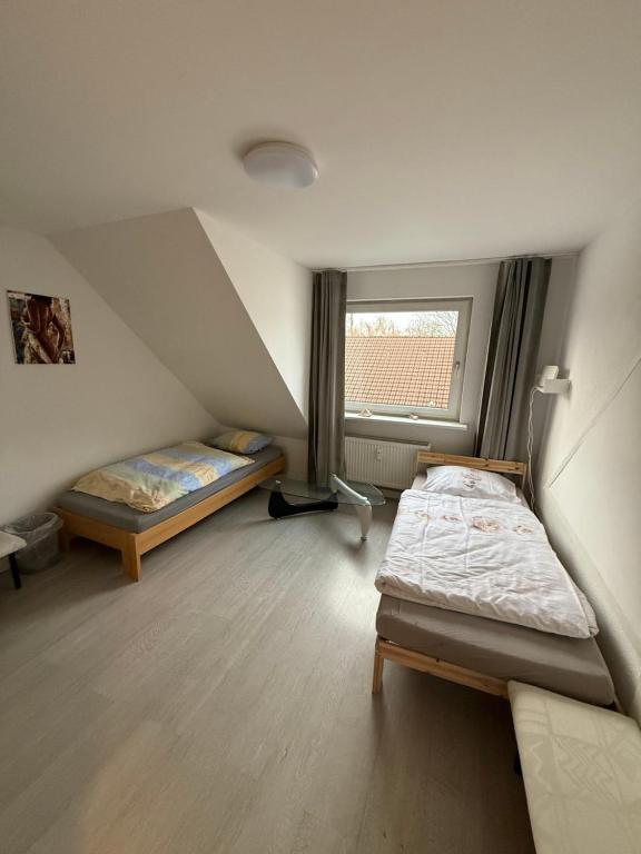 a small room with two beds and a window at Monteurzimmer Schölerpad in Essen