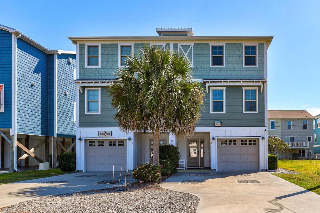 ein Haus mit einer Palme davor in der Unterkunft Great Escape in Kure Beach
