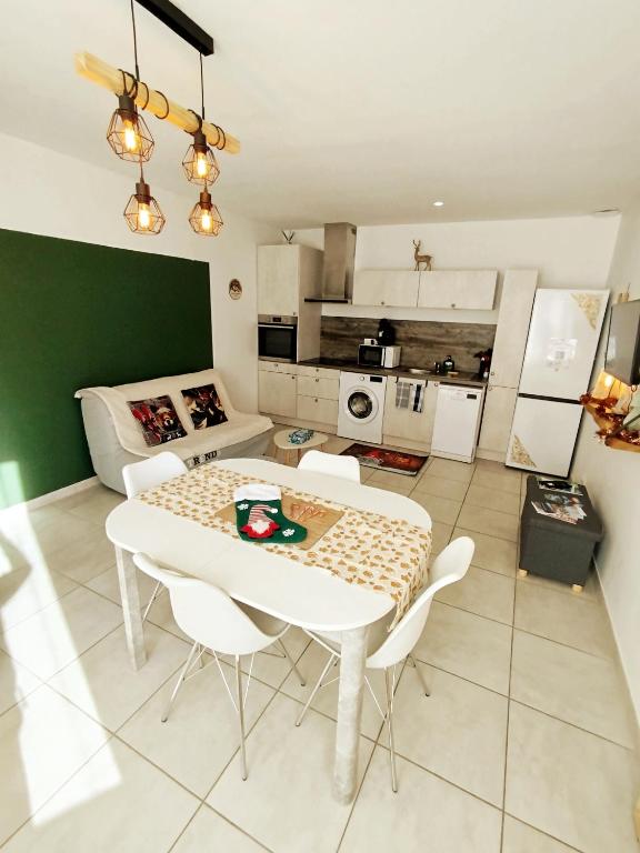 a kitchen with a table and chairs in a room at Appartement centre Ax-les-Thermes proche télécabines & parking in Ax-les-Thermes