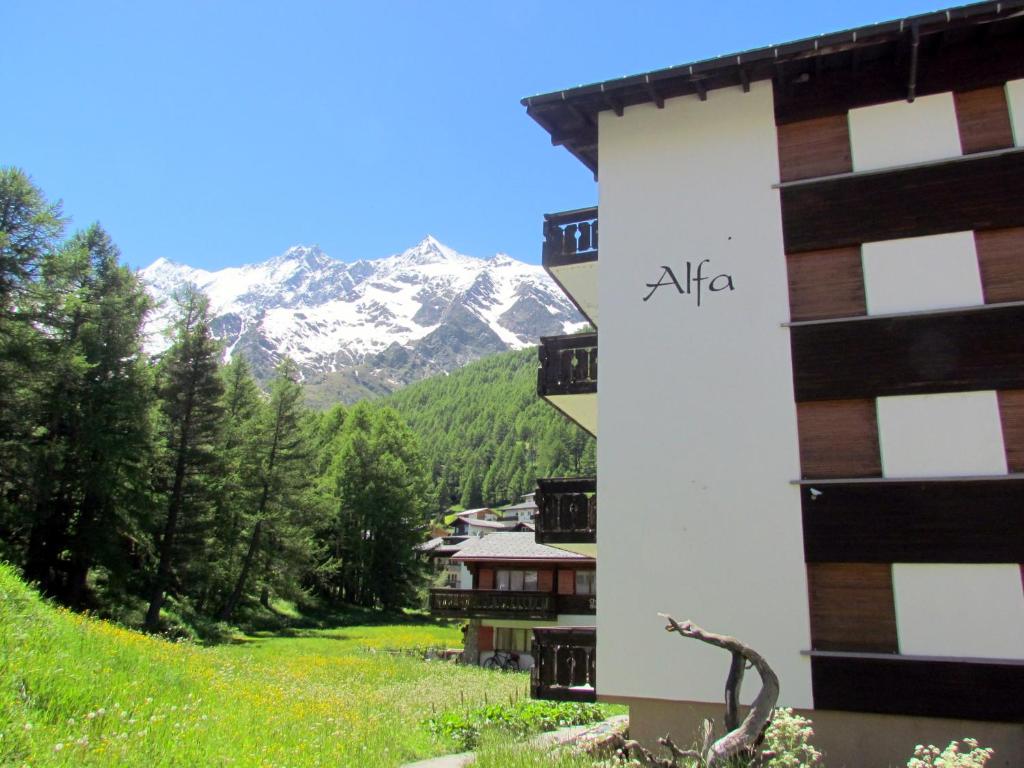 a building with the alia sign on it in the mountains at Haus Alfa in Saas-Fee