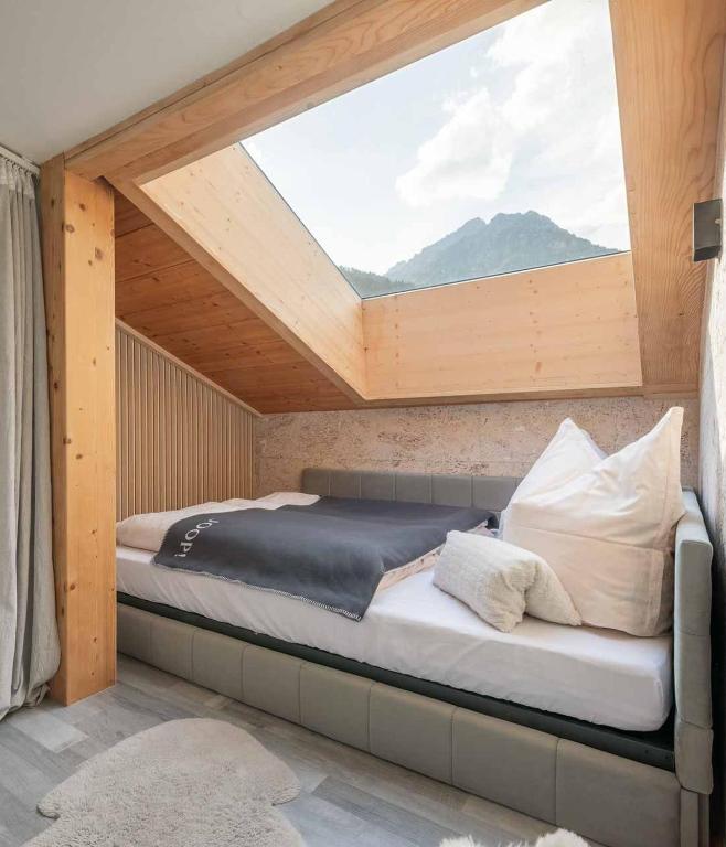 a bed in a room with a large window at Stubainest Schmidt Ferienwohnung in Fulpmes